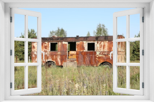 Fototapeta Naklejka Na Ścianę Okno 3D - Rusty radioactive abandoned bus. Dump of radioactive equipment. Chernobyl exclusion zone. Ukraine