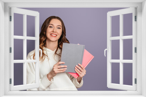 Ukrainian student girl smiles and holds books on a dark gray background copy space