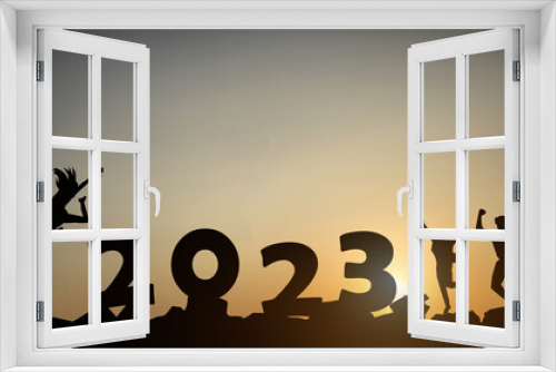Fototapeta Naklejka Na Ścianę Okno 3D - Silhouette of a jumping person with the numbers 2023 on the mountain at sunset against the background of morning sunlight.