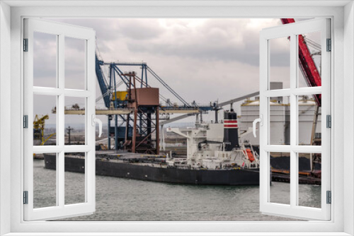 Fototapeta Naklejka Na Ścianę Okno 3D - Unloading a cargo ship in the industrial port of Dunkirk in northern France