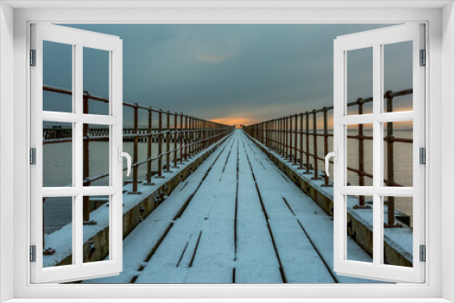 Fototapeta Naklejka Na Ścianę Okno 3D - A freezing, snowy morning at Blyth beach at the old wooden Pier stretching out to the North Sea