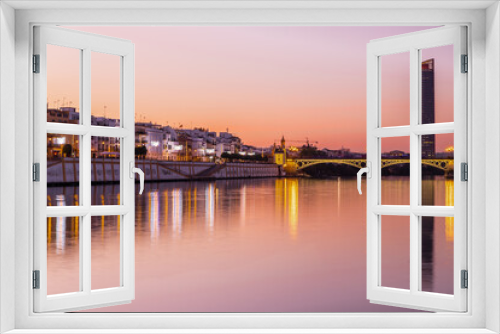 Fototapeta Naklejka Na Ścianę Okno 3D - Sunset over the authentic neighborhood of Tirana in Seville with views on Calle Betis, Torre Sevilla and with awesome reflections in the river Guadalquivir, creating magic atmosphere and views