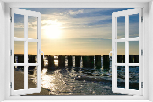Fototapeta Naklejka Na Ścianę Okno 3D - Groynes jut into the sea at sunset. The sun shines on the Baltic Sea. Landscape