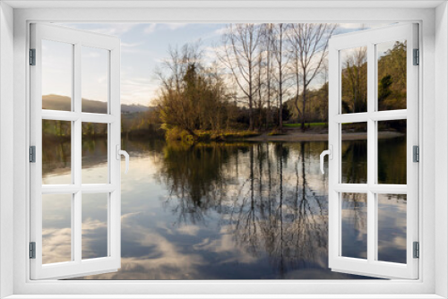 Fototapeta Naklejka Na Ścianę Okno 3D - Bonito recodo de un río en el que se reflejan los árboles y las nubes en sus aguas. Molleda, Asturias, España.