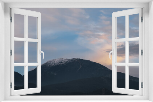 Fototapeta Naklejka Na Ścianę Okno 3D - Distant mountain peaks in the snow against the sunset sky, mountain landscape, idea for a background or wallpaper