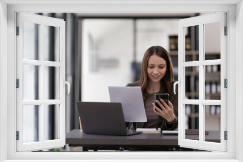 Business woman using smartphone for do math finance on wooden desk in office, tax, accounting, financial concept.