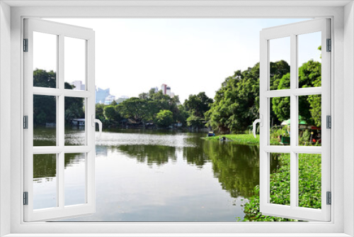 Fototapeta Naklejka Na Ścianę Okno 3D - BANGKOK, THAILAND - JANUARY 16, 2023: The Natural Swamp among the meadow and greenery with natural and waterfront house in bright blue sky background at Thailand.