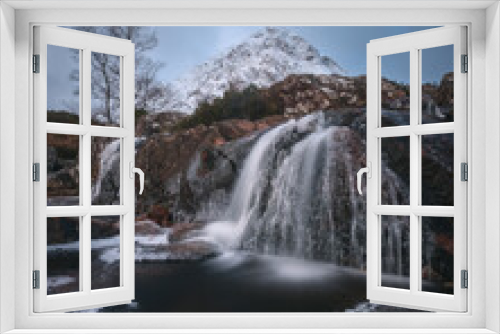 Fototapeta Naklejka Na Ścianę Okno 3D - Mountain river and partially frozen waterfall at the foot of the snow-covered Buachaille Etive Mor. Etive Mor Waterfall. At the entrance to the valley of Glencoe in the Scottish Highlands, Scotland