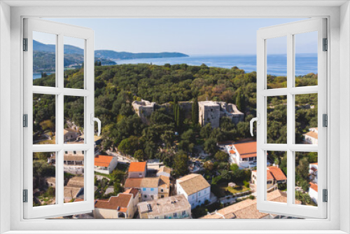 Aerial drone view of Kassiopi, village in northeast coast of Corfu island, Ionian Islands, Kerkyra, Greece in a summer sunny day, with marina, town, beach and castle