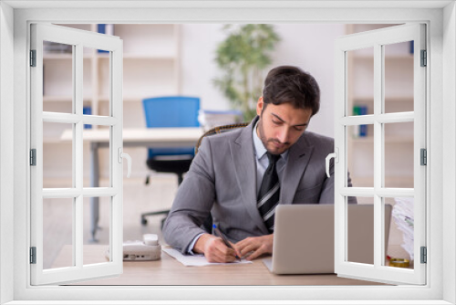 Young male employee and too much work in the office