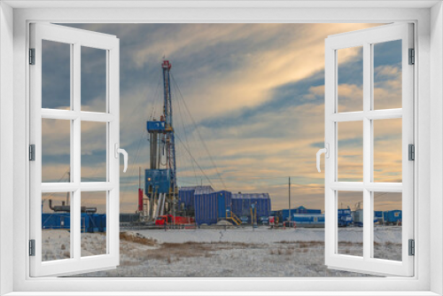 Fototapeta Naklejka Na Ścianę Okno 3D - Drilling wells at an oil and gas field in the Far North. Industrial infrastructure and drilling rig. Beautiful winter sky. Polar Day