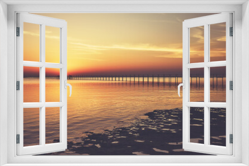 Fototapeta Naklejka Na Ścianę Okno 3D - Seascape with a wooden pier silhouette at sunset, color toning applied.