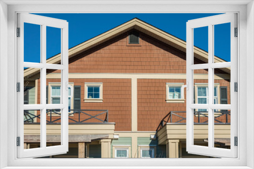 Fototapeta Naklejka Na Ścianę Okno 3D - Top of a house with nice windows. Dormer and a blue sky. Real Estate Exterior Front House in a residential neighborhood