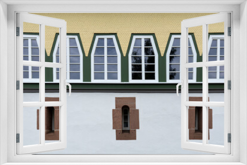 Fototapeta Naklejka Na Ścianę Okno 3D - Reihe von trapezförmigen Fenstern über drei sehr schmalen Fenstern mit Steinrahmen in restaurierter Fassade