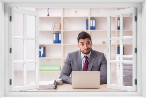 Young male employee unhappy with excessive work in the office