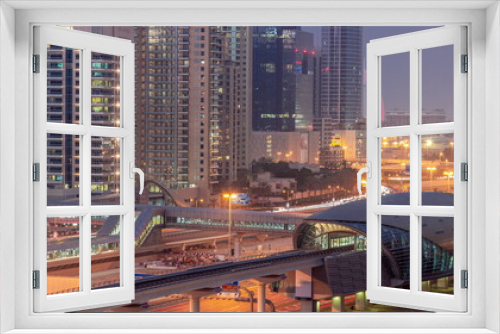 Fototapeta Naklejka Na Ścianę Okno 3D - Futuristic building of Dubai metro station and luxury skyscrapers behind in Dubai Marina aerial day to night