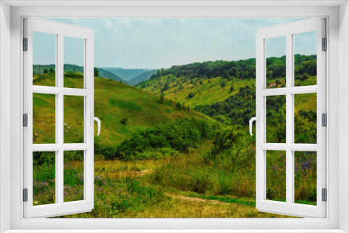 Fototapeta Naklejka Na Ścianę Okno 3D - Idyllic scenery in mountains in national park in summer - green and yellow hills with grass, flowers, bushes and trees, peaceful and scenic landscape, place for travel and calm vacation without people