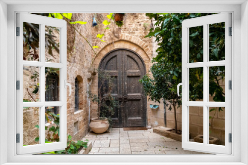 Fototapeta Naklejka Na Ścianę Okno 3D - A wooden arched doorway and door in the historic medieval and ancient old port city of Jaffa, Israel.