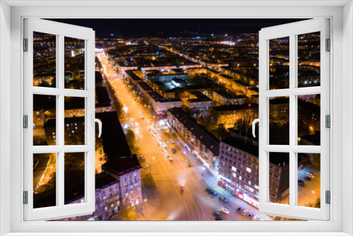 Fototapeta Naklejka Na Ścianę Okno 3D - Top view of the night city in winter. Movement of cars on lighted streets and intersections
