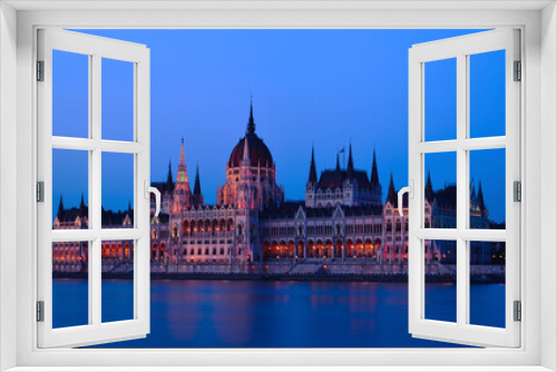 Fototapeta Naklejka Na Ścianę Okno 3D - The Hungarian Parliament in Neo-Gothic style from across the Danube at blue hour. long exposure. blue sky. travel destination. Famous and popular Budapest landmark and tourist attraction. City skyline