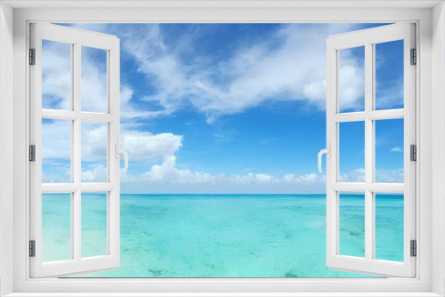 photorealistic panorama view illustration of idyllic beach with blue water and blue sky with white clouds during holiday season, generative ai