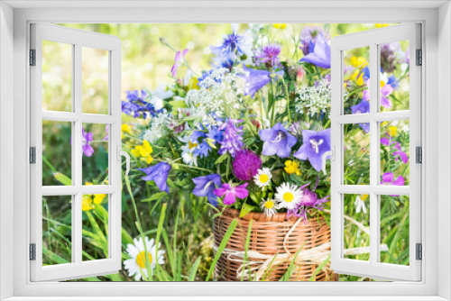 Fototapeta Naklejka Na Ścianę Okno 3D - Meadow flowers bouquet in wicker mug on nature background outdoors in natural morning light, still life with vivid wild flowers in background of nature in summertime, close up view