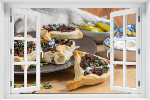 Fototapeta Naklejka Na Ścianę Okno 3D - Traditional cookie Hamantasch with beef meat, tahini sauce and fresh thyme for Jewish holiday Purim on wooden background.