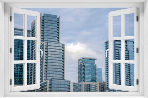 Fototapeta Naklejka Na Ścianę Okno 3D - Glass buildings on a cityscape views from Butler Metro Park at Austin, Texas. Modern city residential and corporate buildings against the cloudy sky.
