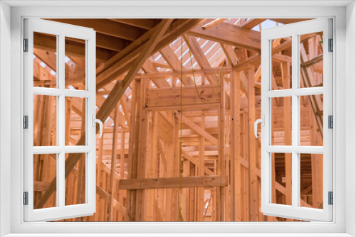 Fototapeta Naklejka Na Ścianę Okno 3D - As part construction newly constructed stick house wooden roof rafter timber beams which will be supported by truss frames