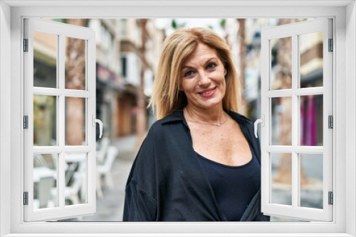 Middle age blonde woman smiling confident standing at street