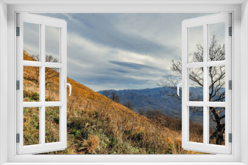 The slope of the mountain with dry grass. Mountain landscape with beautiful Caucasian nature. View from a great height in a picturesque place of the Caucasus. Caucasian mountain landscape.