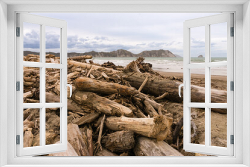 Fototapeta Naklejka Na Ścianę Okno 3D - Forestry slash on Tolaga Bay beach, NZ following a storm that washed the slash off the surrounding hills and into the rivers that flow into the ocean.
 