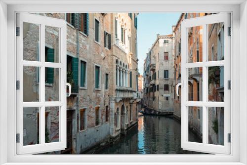 Fototapeta Naklejka Na Ścianę Okno 3D - Venice Canal is lined on either side by Romanesque, Gothic, and Renaissance buildings in Venice, Italy.