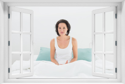 Portrait of a serious woman sitting in bed