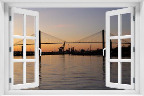 Fototapeta Naklejka Na Ścianę Okno 3D - The 1991 cable-stayed Talmadge Memorial Bridge over the Savannah River seen in silhouette during a golden hour sunset