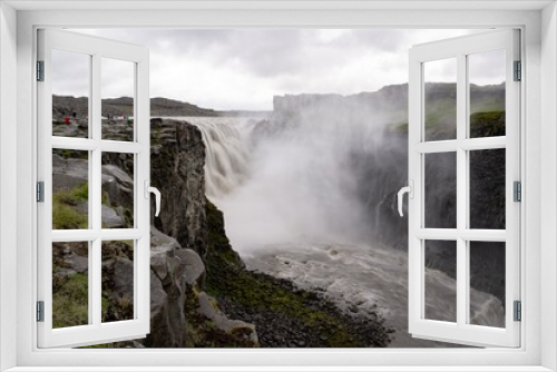Fototapeta Naklejka Na Ścianę Okno 3D - Spectacular Dettifoss waterfall in Iceland after floods filled with muddy water and tourists in raincoats