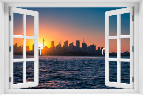 Beautiful Sunset behind Skyline of Sydney seen from the Sea, New South Wales, Australia.
