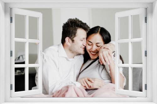 Photo of young couple laughing on a sofa. Concept of lifestyle, love, friendship, affection and feelings.