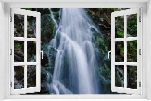 Fototapeta Naklejka Na Ścianę Okno 3D - Beautiful mountain rainforest waterfall with fast flowing water and rocks, long exposure. Natural seasonal travel outdoor background with sun shining. Stream waterfall on rocks in the forest