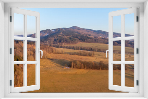 A winter landscape without snow. A clear evening during sunset over the hills of the Lusatian Mountains, Czech Republic. Aerial drone view.