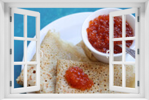 Fototapeta Naklejka Na Ścianę Okno 3D - Crepes with red caviar on a white plate. Blue textured background with copy space. Delicious breakfast close up photo. 