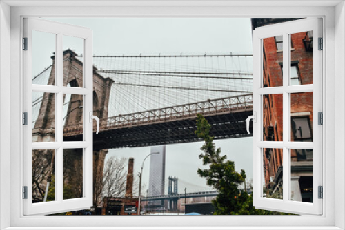 Fototapeta Naklejka Na Ścianę Okno 3D - Fotografía angular del Puente de Brooklyn desde un ángulo inferior (New York City, Estados Unidos).
