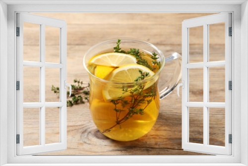 Fototapeta Naklejka Na Ścianę Okno 3D - Aromatic herbal tea with thyme and lemon on wooden table