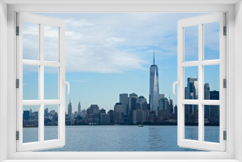 Fototapeta Naklejka Na Ścianę Okno 3D - Looking back on Manhattan from the Hudson River and Liberty Island, as the towering high rises of Lower Manhattan loom above the river