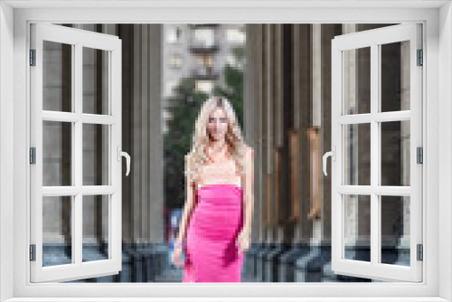 blond fashion woman walking between columns