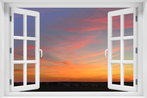 Fototapeta Naklejka Na Ścianę Okno 3D - A stunning sunset with orange, yellow and red colors on a blue sky and clouds 