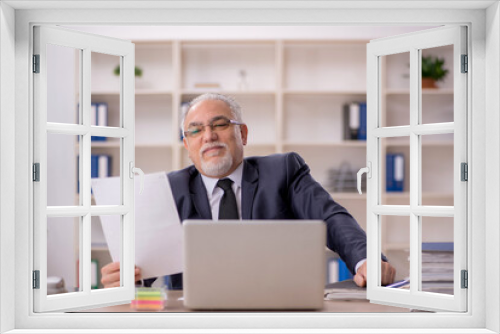 Old male employee working in the office