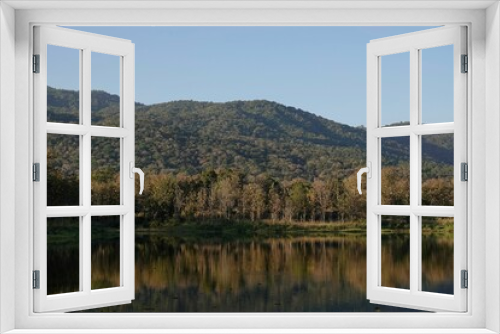 Fototapeta Naklejka Na Ścianę Okno 3D - River reflecting trees and mountains on the shore on a sunny day