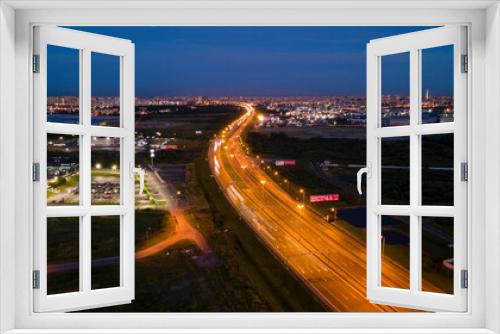 Fototapeta Naklejka Na Ścianę Okno 3D - Aerial above view of the bigger highway with bigger traffic cars next to forest and the historical and at same time modern city of St. Petersburg at light summer night