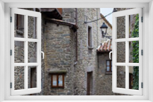 Fototapeta Naklejka Na Ścianę Okno 3D - Calle de pueblo de montaña con ventanas balcones y farola